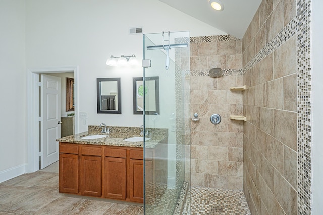 full bathroom featuring vaulted ceiling, tiled shower, and double vanity