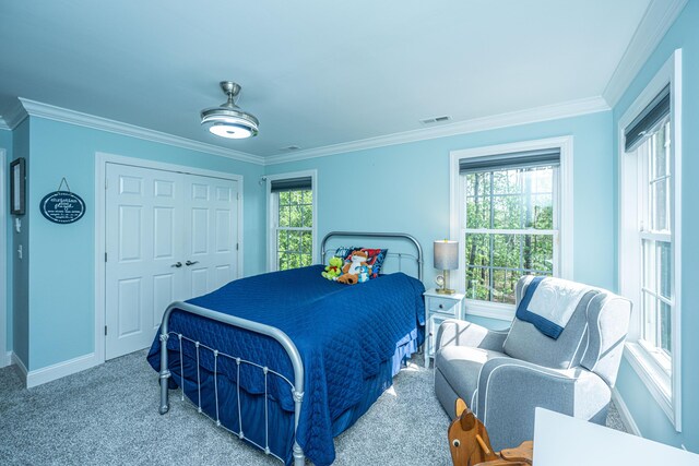 bedroom with crown molding, baseboards, carpet flooring, and a closet