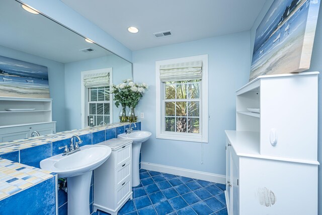 bathroom with tile patterned floors, baseboards, recessed lighting, and two sinks