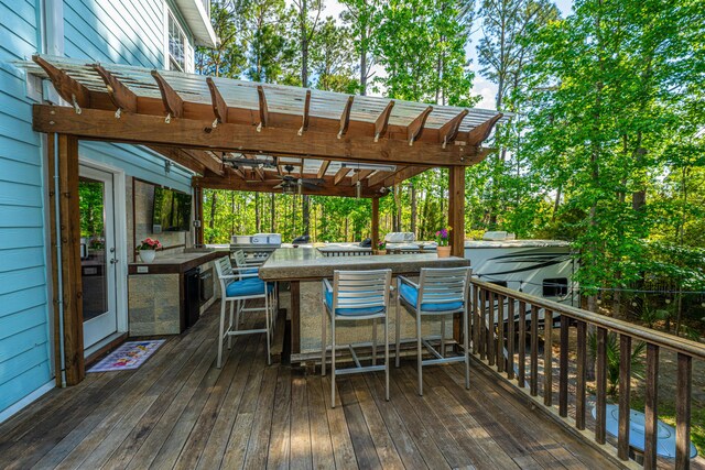 wooden terrace featuring an outdoor kitchen and a pergola