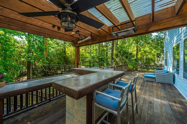 deck featuring a ceiling fan and view of scattered trees