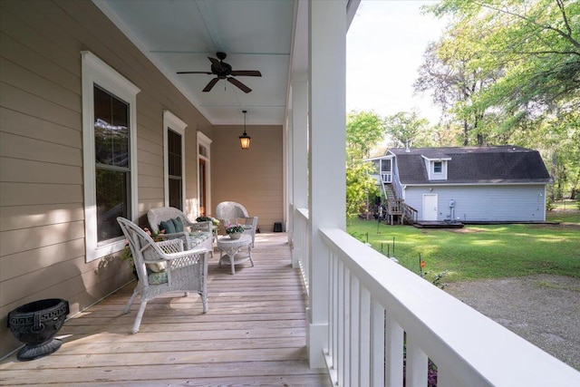 wooden terrace with a lawn and a ceiling fan