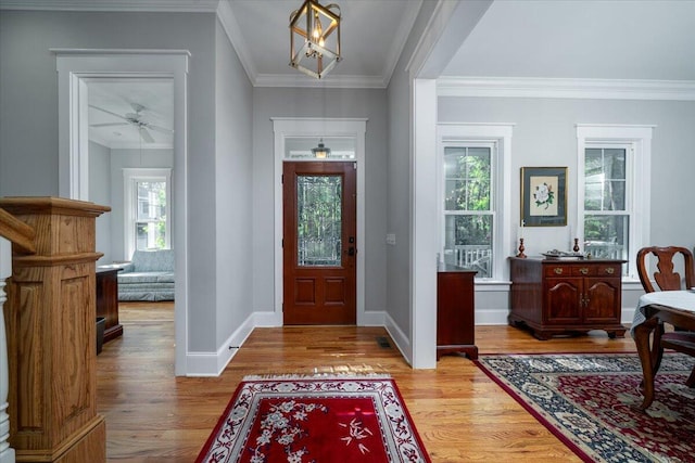 foyer with crown molding, baseboards, ceiling fan, and wood finished floors