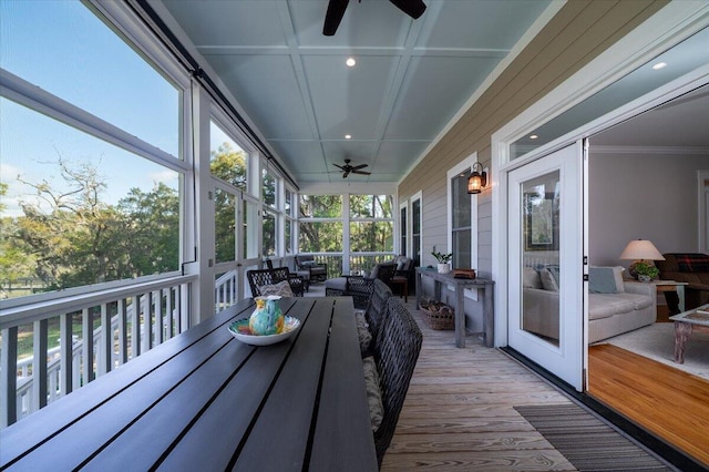 sunroom / solarium featuring a ceiling fan and outdoor dining space