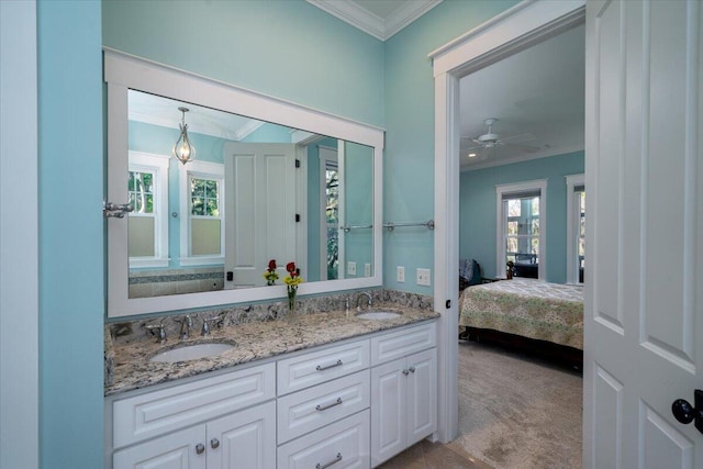 bathroom with a sink, crown molding, double vanity, and connected bathroom