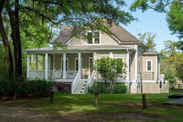 view of front of house featuring a porch, a ceiling fan, a front lawn, and stairway