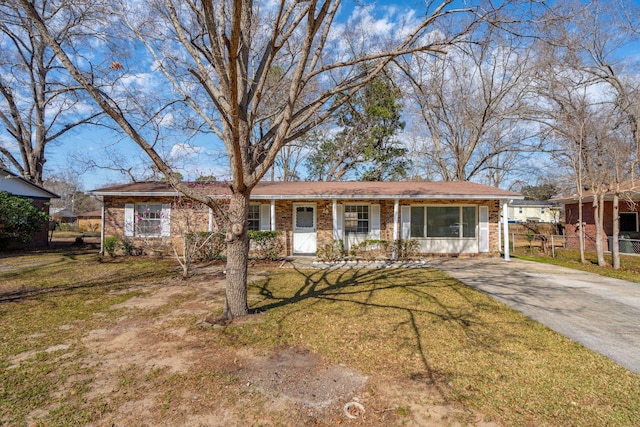 ranch-style home with brick siding, concrete driveway, a front yard, and fence