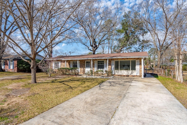 ranch-style house featuring concrete driveway, a porch, and a front lawn