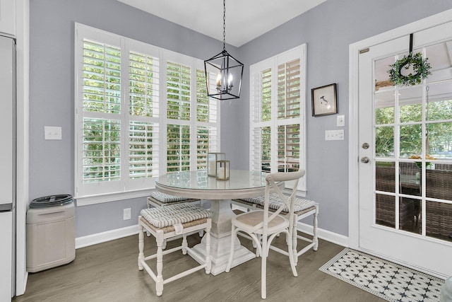 dining room with baseboards, a notable chandelier, and wood finished floors