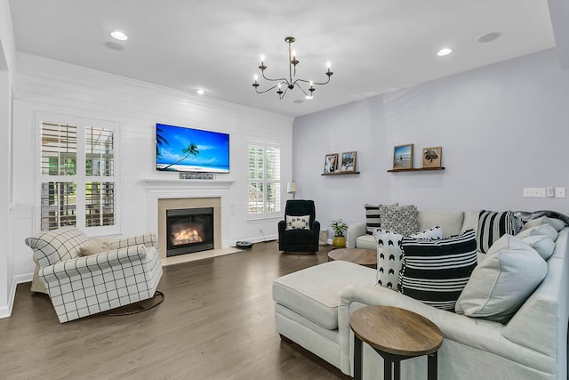 living area featuring recessed lighting, a chandelier, a fireplace with flush hearth, and wood finished floors
