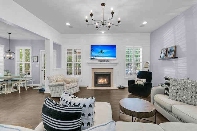 living room with an inviting chandelier, a fireplace with flush hearth, recessed lighting, and wood finished floors
