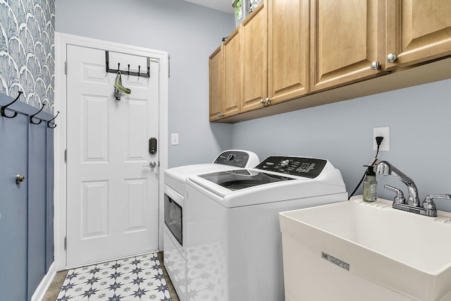 clothes washing area featuring cabinet space, a sink, separate washer and dryer, baseboards, and light floors