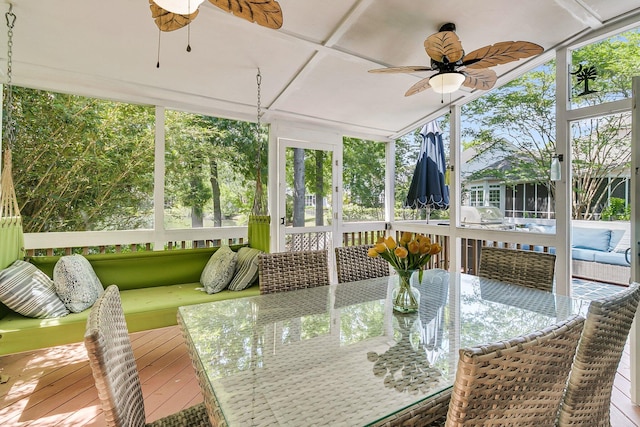 sunroom / solarium with a ceiling fan and outdoor dining area