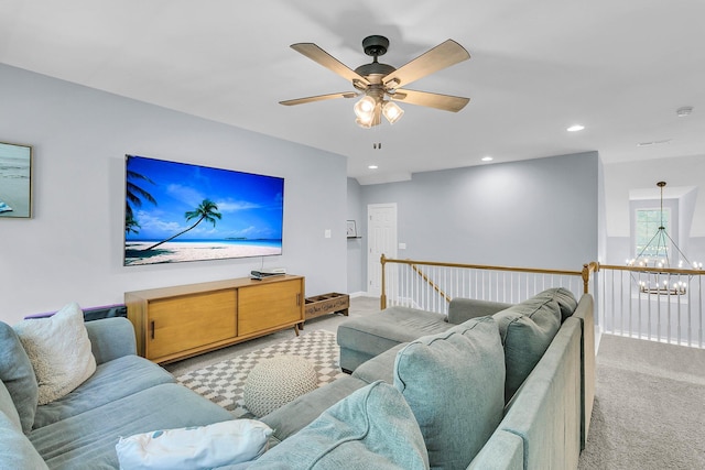 living area featuring recessed lighting, baseboards, light colored carpet, and ceiling fan with notable chandelier