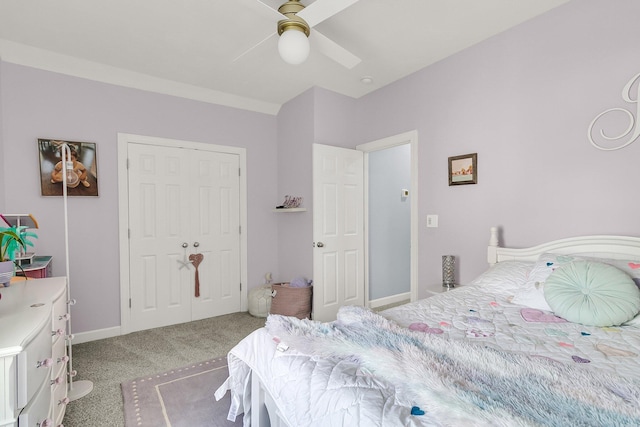 bedroom with ceiling fan, light carpet, baseboards, and a closet
