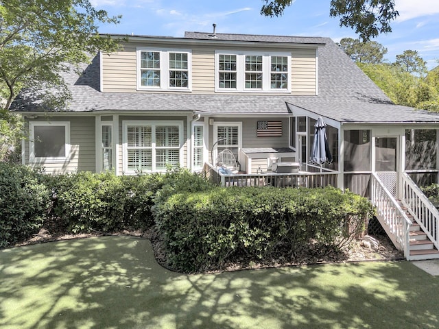 rear view of house with a shingled roof and a sunroom