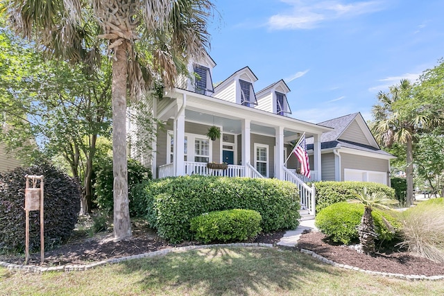 cape cod house with a garage and a porch
