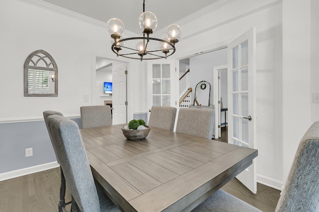 dining area with baseboards, a notable chandelier, wood finished floors, and stairway