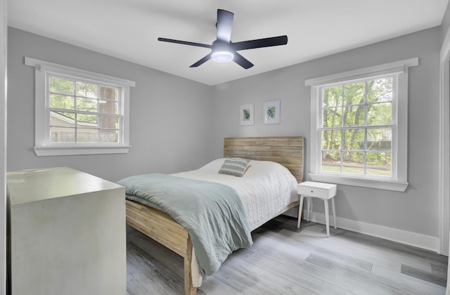 7674 Chippendale Rd, North Charleston, SC 29420 - bedroom featuring multiple windows, light wood-type flooring, and baseboards