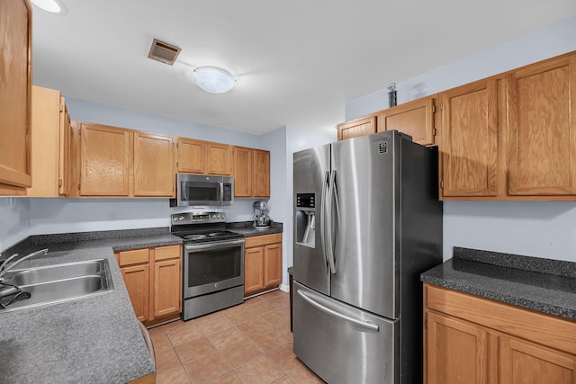 1309 Llewellyn Rd, Mount Pleasant, SC 29464 - kitchen with stainless steel appliances, a sink, light tile patterned floors, and dark countertops