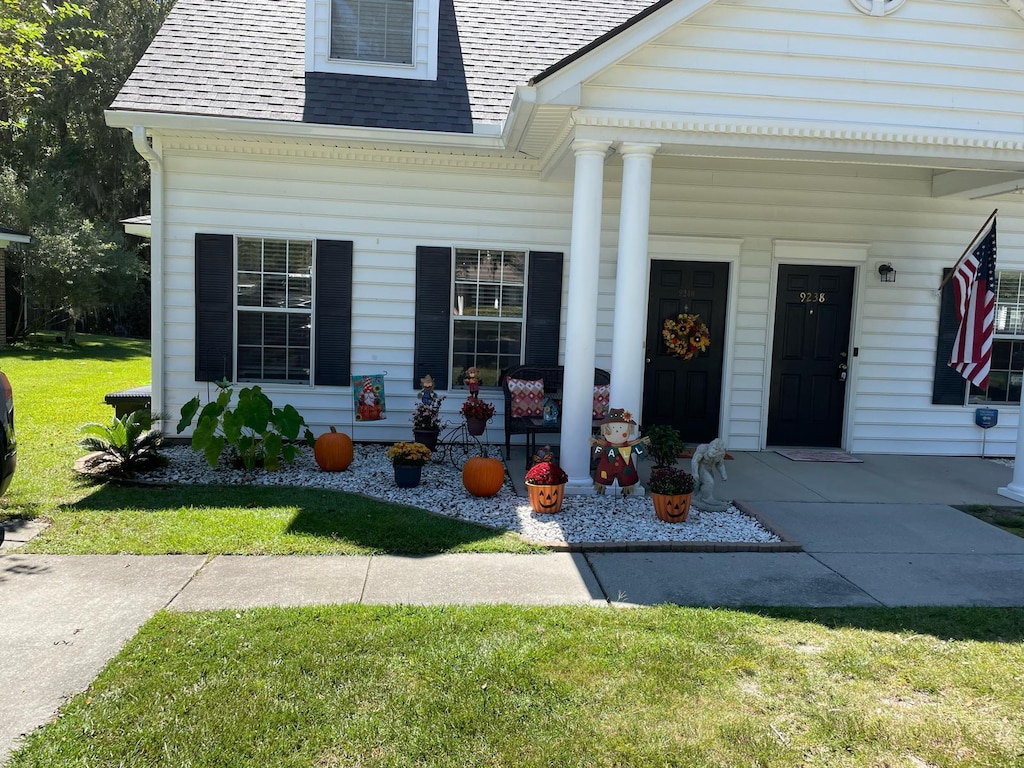 view of front of house with covered porch and a front yard