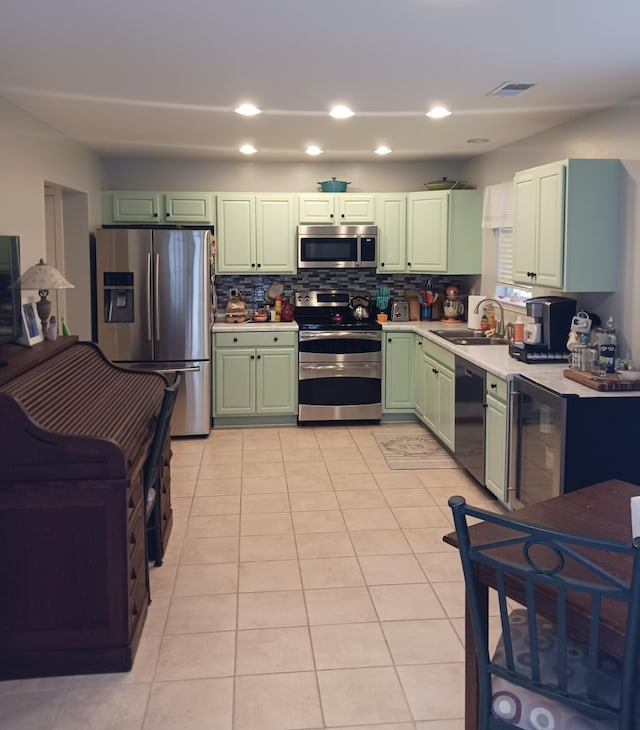 kitchen featuring light tile patterned flooring, stainless steel appliances, sink, and decorative backsplash