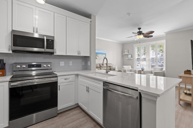 130 River Landing Dr Unit 9104, Charleston, SC 29492 - kitchen with appliances with stainless steel finishes, light wood-style floors, a peninsula, crown molding, and backsplash