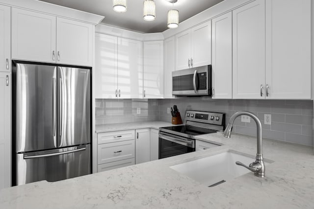 130 River Landing Dr Unit 9104, Charleston, SC 29492 - kitchen with stainless steel appliances, light stone counters, and white cabinets