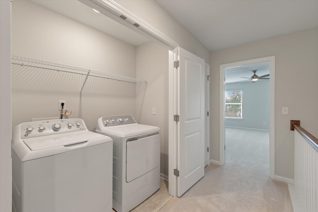 washroom featuring light carpet, laundry area, washing machine and dryer, and baseboards