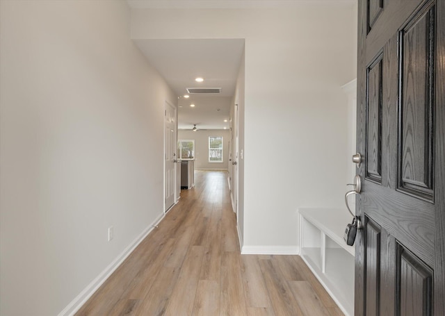 hall featuring light wood-type flooring, baseboards, visible vents, and recessed lighting