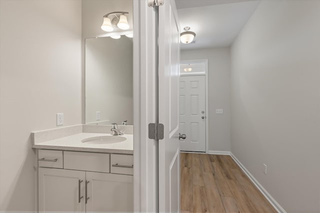 bathroom with vanity, baseboards, and wood finished floors