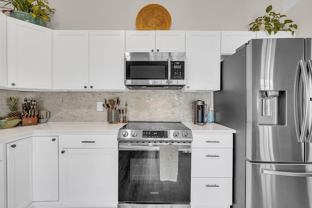 kitchen with light countertops, appliances with stainless steel finishes, white cabinetry, and decorative backsplash