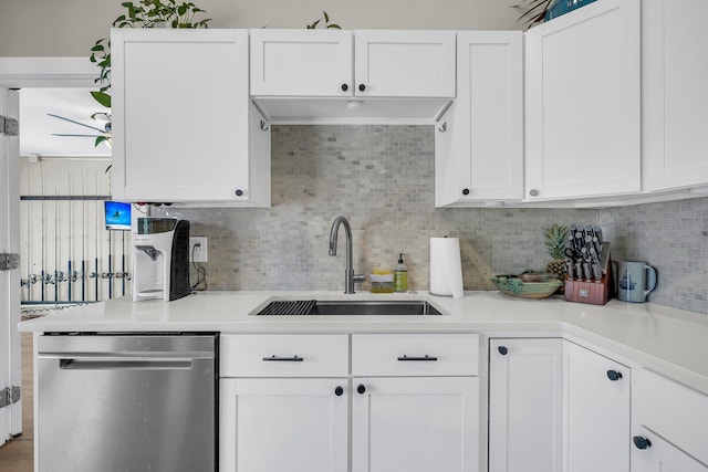 kitchen with a sink, white cabinets, light countertops, and dishwasher