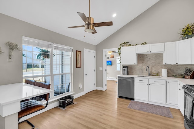 kitchen with stainless steel appliances, a sink, light countertops, and white cabinets