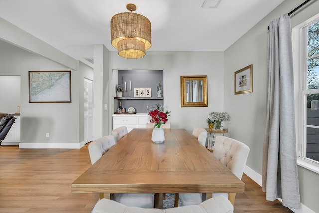 dining area featuring baseboards, a chandelier, and wood finished floors