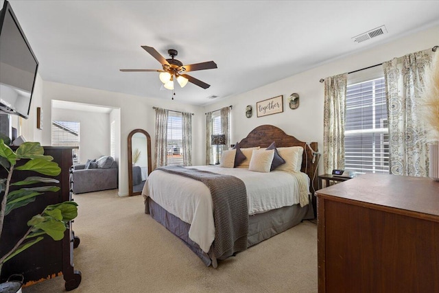 bedroom featuring light carpet, ceiling fan, and visible vents