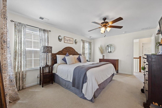 bedroom with baseboards, multiple windows, visible vents, and light colored carpet