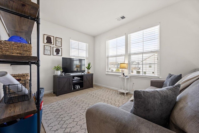 living room with baseboards, visible vents, and carpet flooring