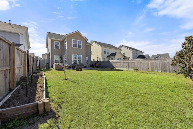 view of yard with a garden, a residential view, and a fenced backyard