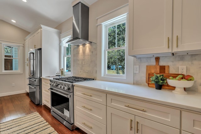 kitchen featuring premium appliances, dark wood-type flooring, decorative backsplash, and wall chimney exhaust hood