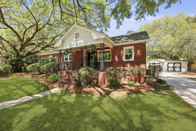 view of front facade with an outdoor structure, brick siding, a front lawn, and covered porch