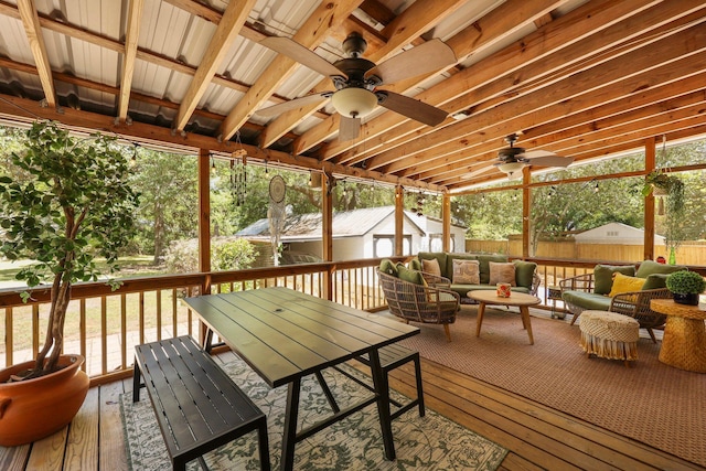 sunroom with outdoor lounge area, outdoor dining area, ceiling fan, and a healthy amount of sunlight