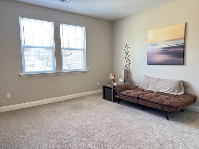 living room with light carpet, visible vents, and baseboards