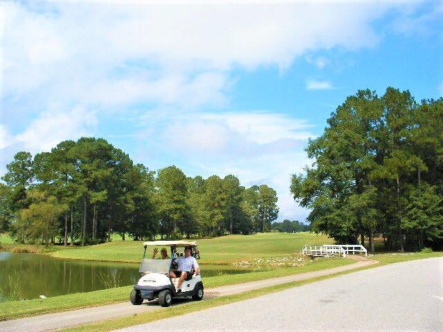 surrounding community featuring a water view and a lawn