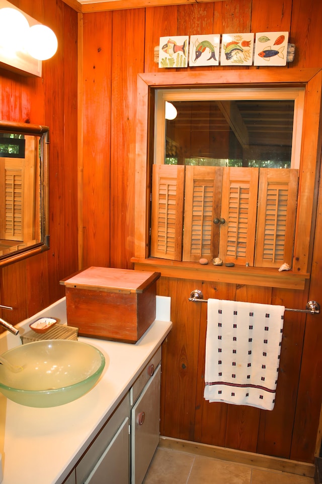 bathroom featuring tile patterned floors, wooden walls, and vanity