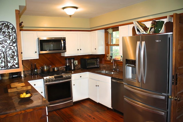 kitchen featuring white cabinetry, appliances with stainless steel finishes, sink, and dark hardwood / wood-style flooring