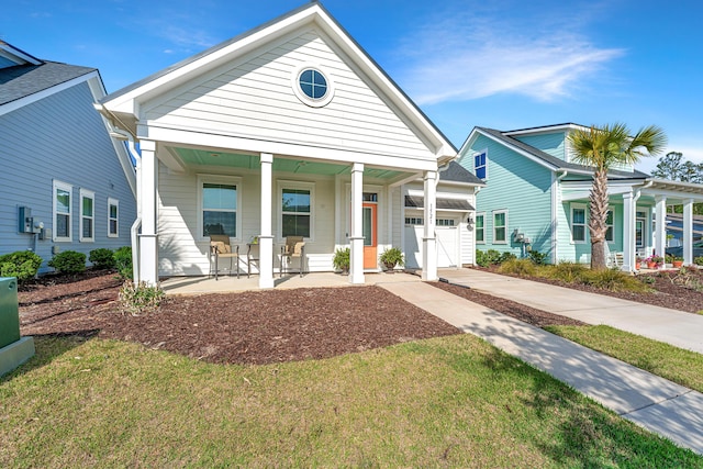 view of front of house featuring a garage, concrete driveway, a front lawn, and covered porch
