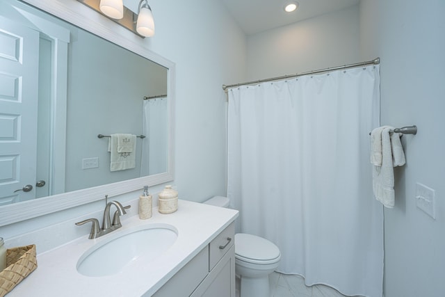 bathroom featuring recessed lighting, toilet, and vanity