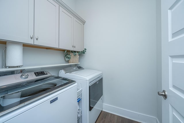 washroom with washing machine and clothes dryer, cabinet space, dark wood-style floors, and baseboards