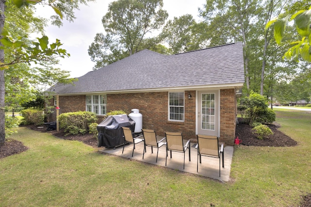 256 Ridge Lake Dr, Manning, SC 29102 - back of house with a shingled roof, a patio, brick siding, and a yard